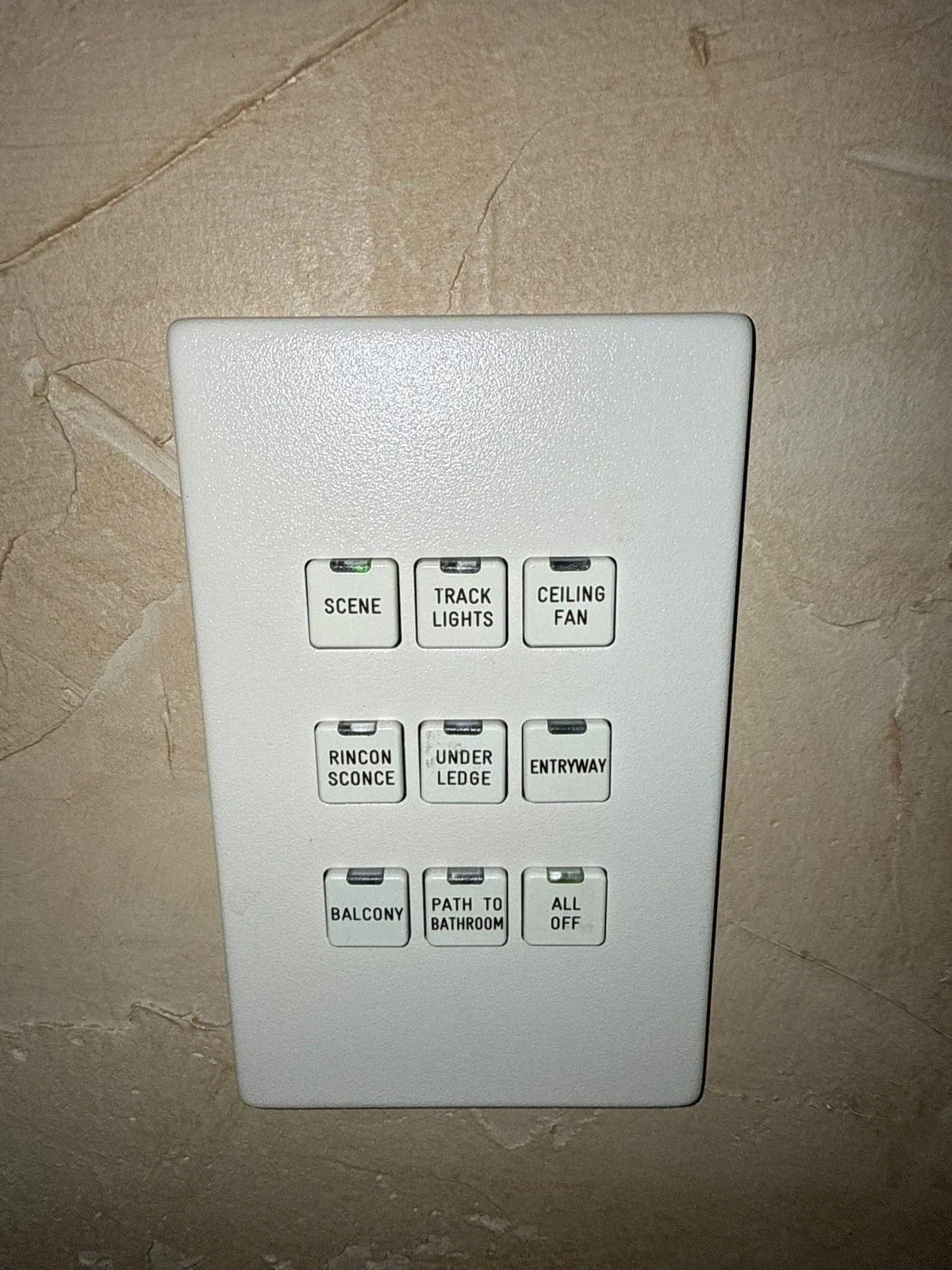 Original LiteTouch keypad on a wall, with labeled scene and lighting buttons