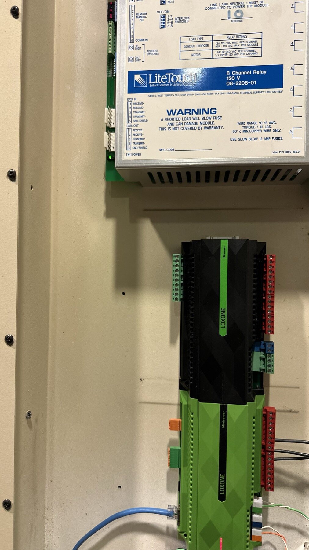 A LOXONE Miniserver mounted directly beneath a still-installed LiteTouch 8 Channel Relay Module inside the original equipment enclosure
