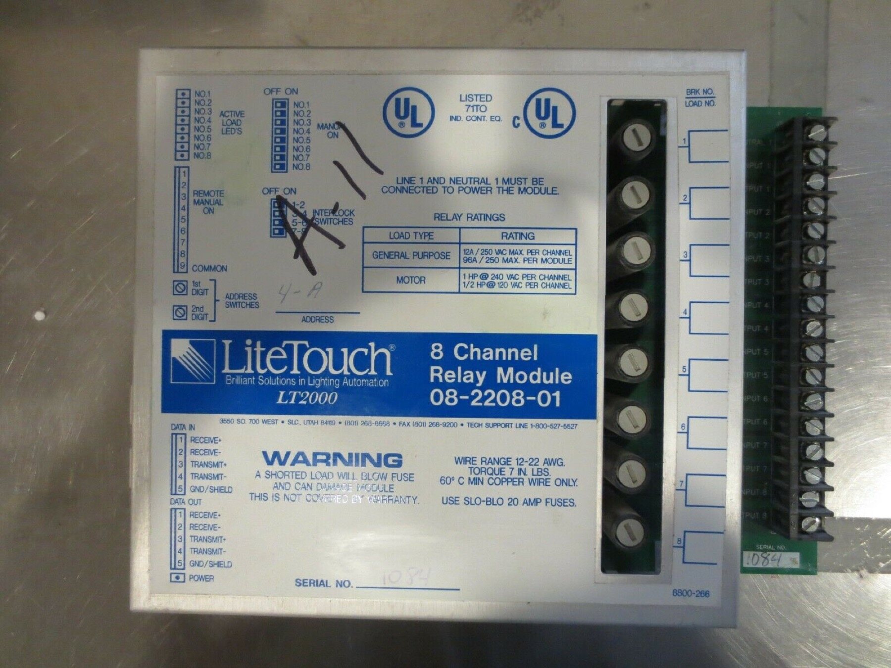 A LiteTouch 8 Channel Relay Module 08-2208-01 removed from its panel, showing the address switches, interlock switches and per-channel load terminals